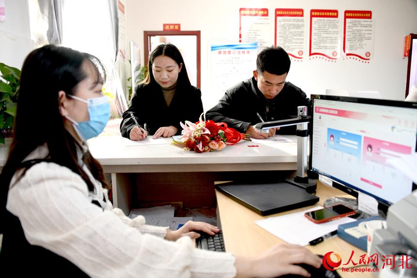 河北省邯鄲市廣平縣婚姻登記處，一對新人填寫信息領取結婚証。楊海斌攝