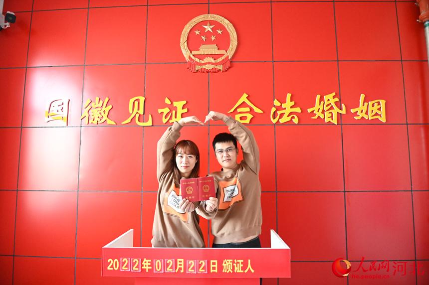 2022年2月22日，在河北省邯鄲市館陶縣民政局婚姻登記處，一對新人領取結婚証后拍照留念。 胡清華攝