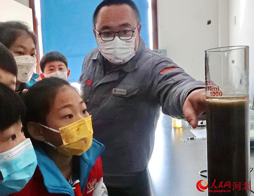 ?2022年3月21日,秦皇岛市第一污水处理厂工作人员为海港区明珠学校学生演示污泥沉降比实验。 曹建雄摄