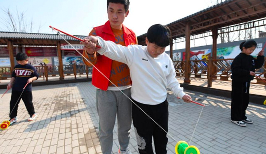 在文安縣大留鎮小學紅色文化教育基地，志願者正在教孩子們抖空竹。 高丹鈺攝