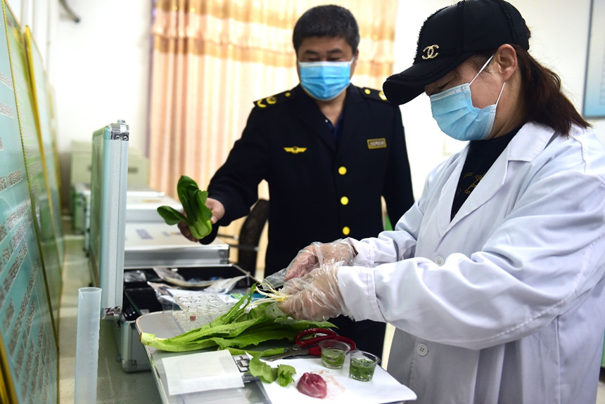 当地市场监督管理局工作人员对蔬菜批发市场各类蔬菜、肉产品进行抽样检验。 傅新春摄