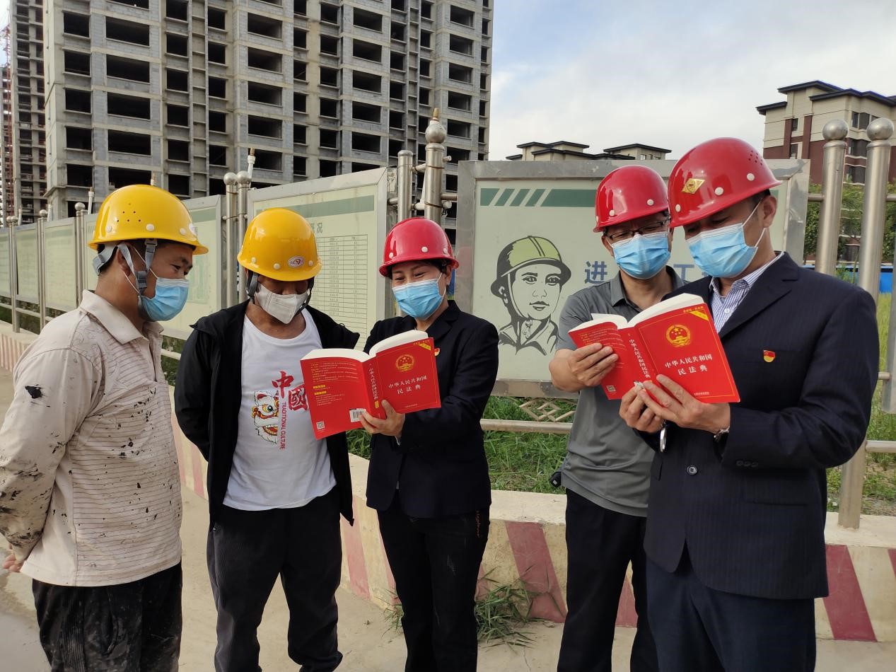 宣讲人员（右一、右三）走进东光县各施工单位，为建筑工人解读法律知识。 张金元摄