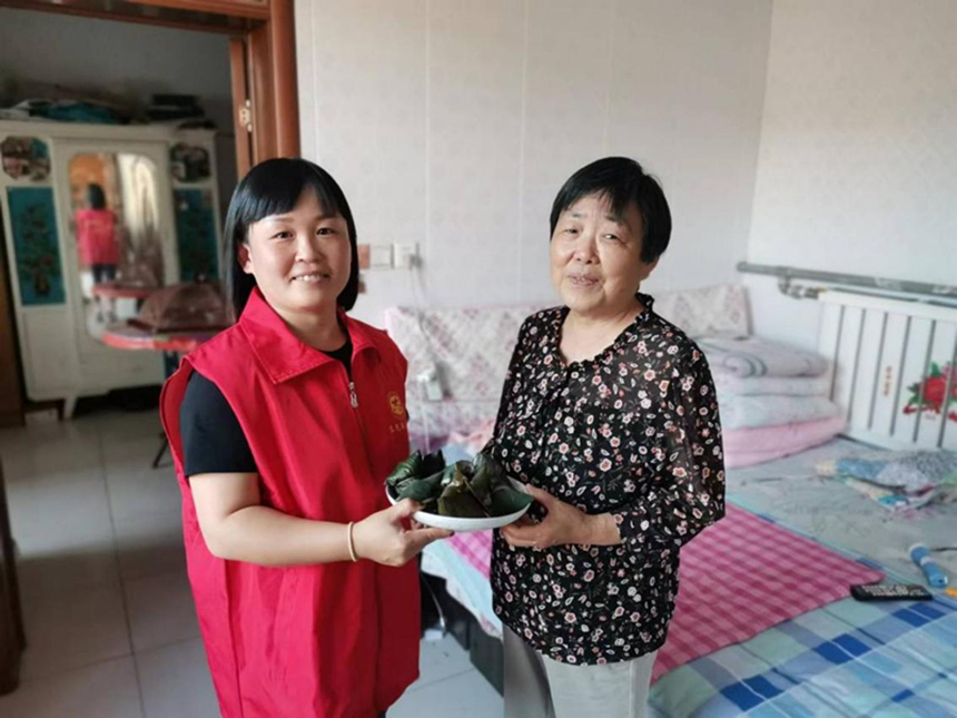 东光县于桥乡新时代文明实践中心的志愿者将热气腾腾的粽子送到独居老人手中。 杨婷摄