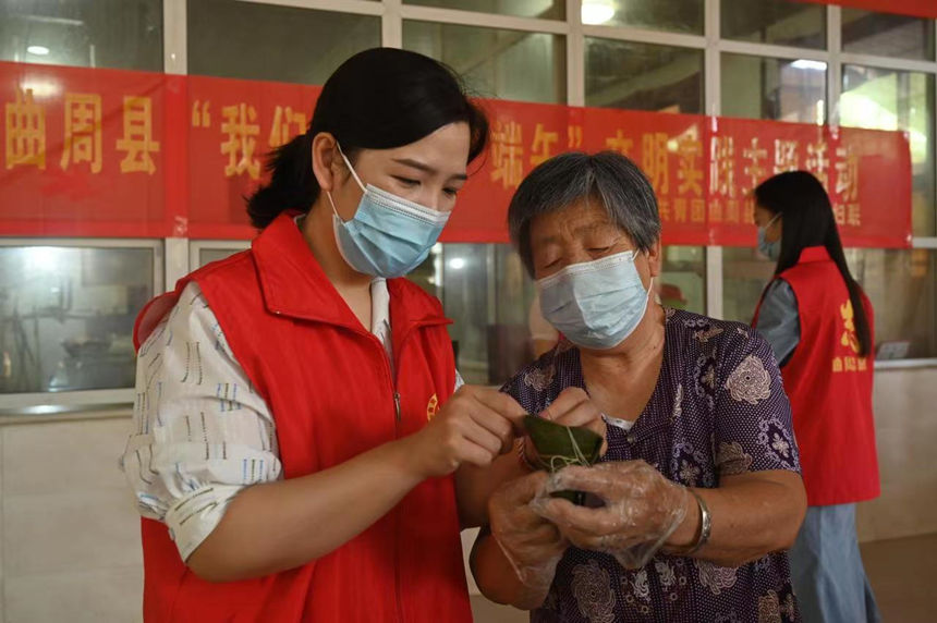 河北省曲周县志愿者与当地养老中心的老人一起包粽子。王喜民摄