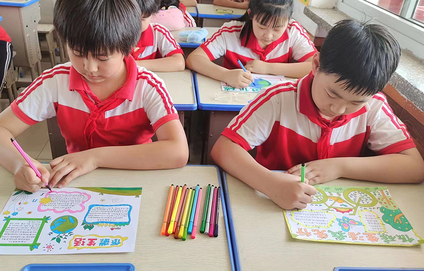 育红小学学生绘制节能低碳宣传手抄报。吕林摄