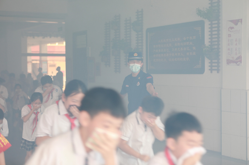 6月16日，河北省邯鄲市邯山區實驗小學學生在消防員的引導下進行火場逃生演練。李昊攝