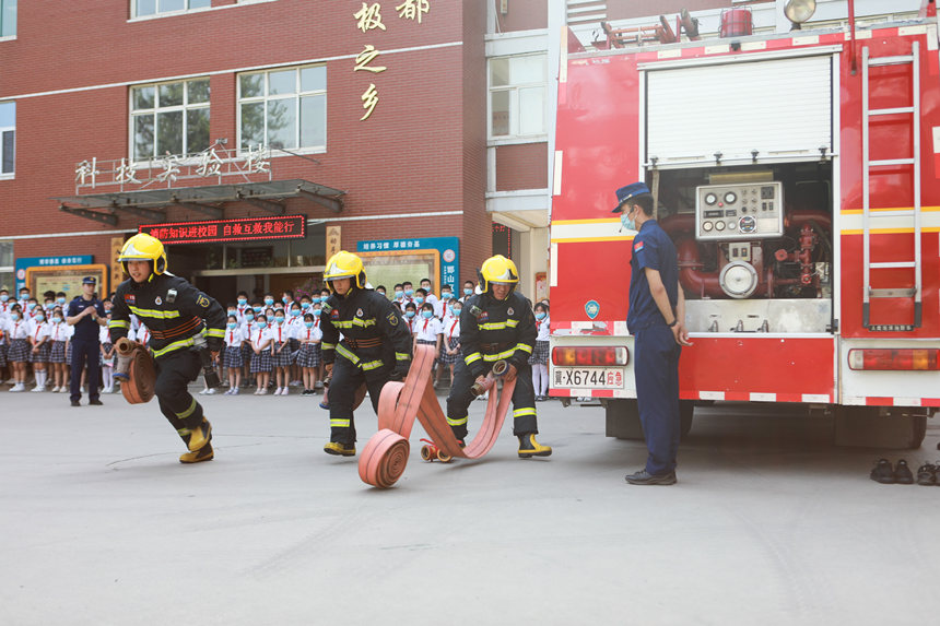 6月16日，河北省邯鄲市邯山區消防救援大隊消防員為學生們示范消防水帶的使用方法。李燊攝