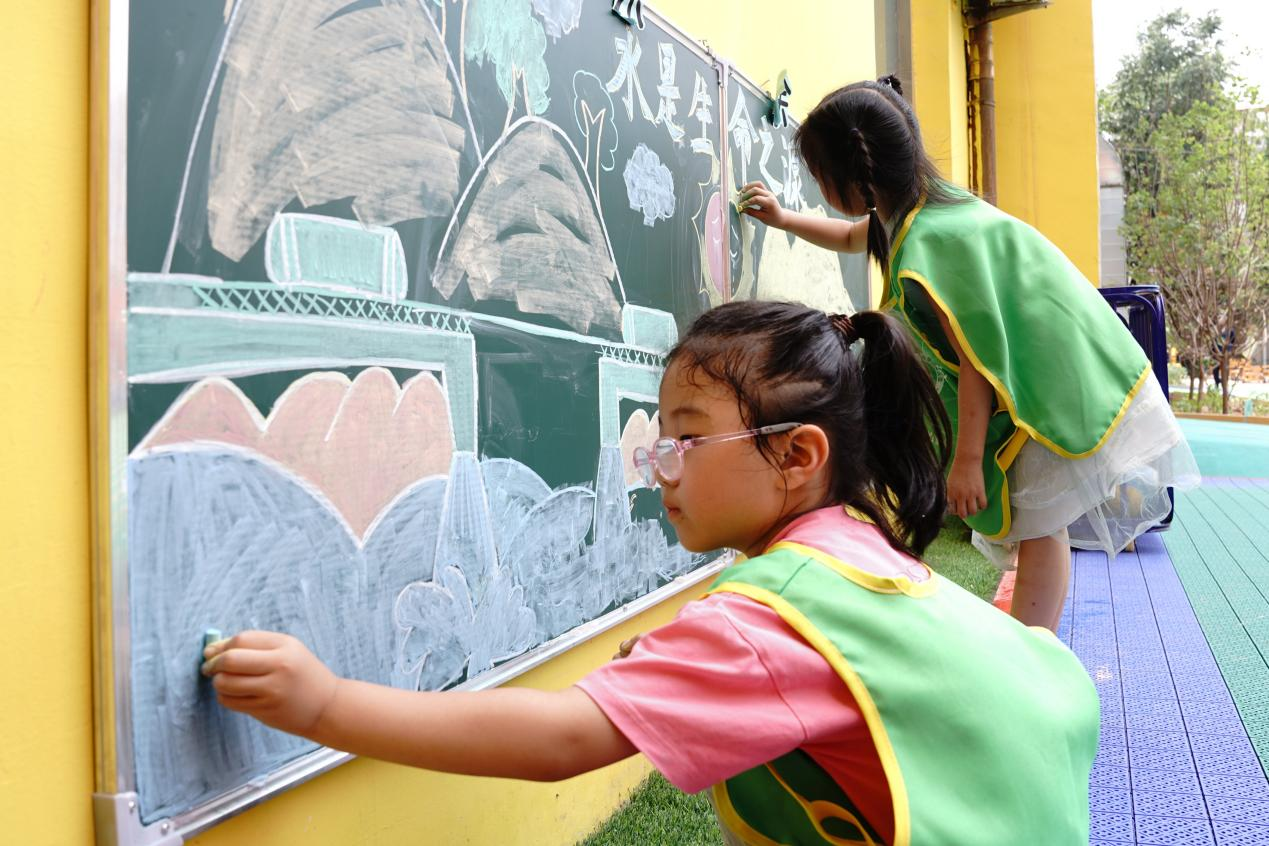 河北省邢台市巨鹿縣縣直第六幼兒園的孩子們繪制節約用水主題黑板報。 陳佳兵攝