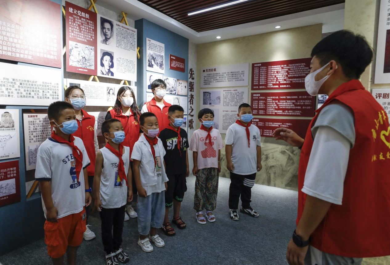 志願者與孩子們一起唱響歌曲《沒有共產黨就沒有新中國》。 陳軍攝