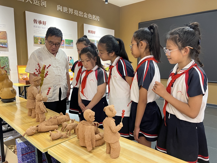 非遗传承人金葆政向学生们讲解泥人工艺。 孟悦摄