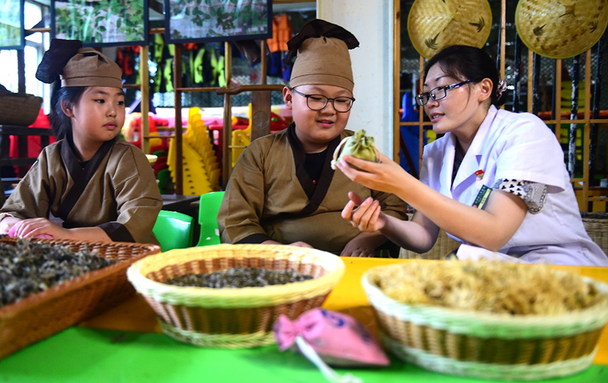 沧州市人民医院国医馆的中医向孩子传授驱蚊中药香包的制作工艺。 傅新春摄