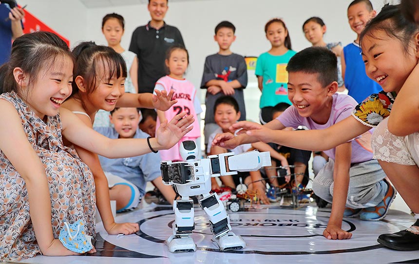 2022年7月19日，河北省秦皇岛市海港区白塔岭街道秦皇半岛第二社区内，小朋友正在观看“机器人跳舞”。 曹建雄摄
