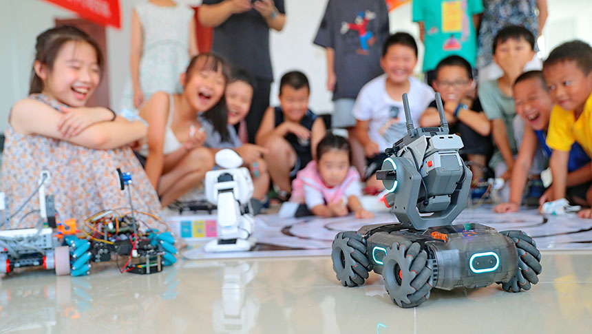 2022年7月19日，河北省秦皇岛市海港区白塔岭街道秦皇半岛第二社区内，小朋友正在观看“机甲机器人表演”。 曹建雄摄