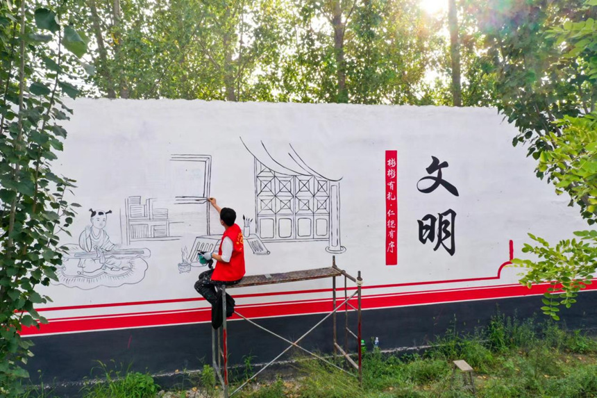 河北省唐山市丰南区东田庄乡青年志愿者正在绘制文化墙。高林林摄