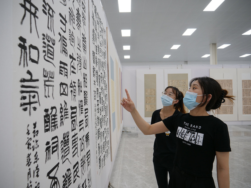 书法爱好者在欣赏书法临帖作品。 于丰涛摄