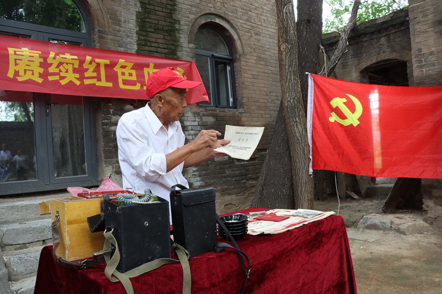 在邯郸市复兴区二六七二街道后牛叫村进士府，老支书为学生讲述抗战时期的老物件。 王伸摄