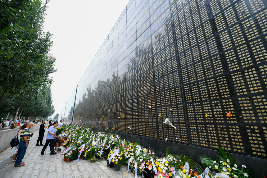 市民來到唐山地震罹難者紀念牆祭奠已故親人。趙亮攝