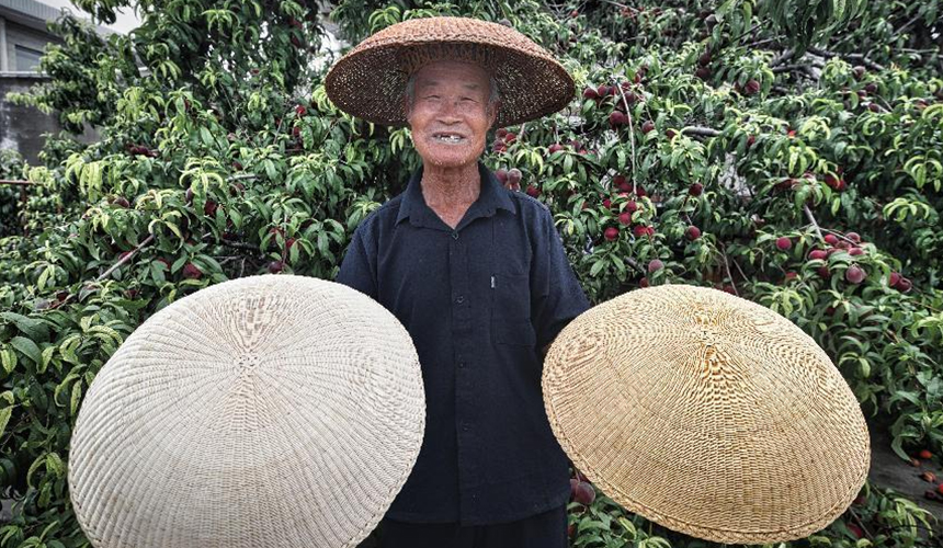 王恩大正在展示亲手编织的草帽成品。毕帅摄