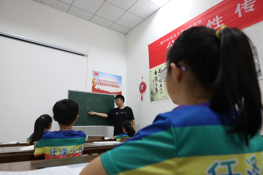 河北省邢台市任泽区暑期夏令营的老师在教孩子们学习硬笔书法。 陈惠浩摄