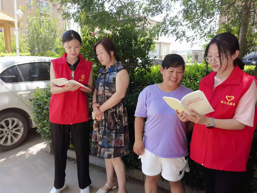 大学生宣讲团的志愿者带领群众学习。 张文娟摄