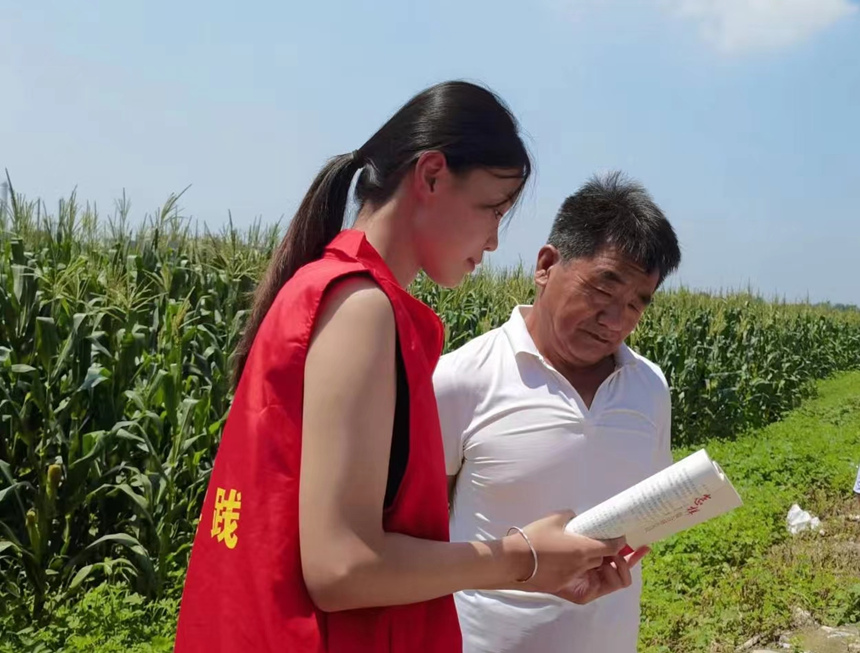 大学生宣讲团的志愿者带领群众学习。 张文娟摄