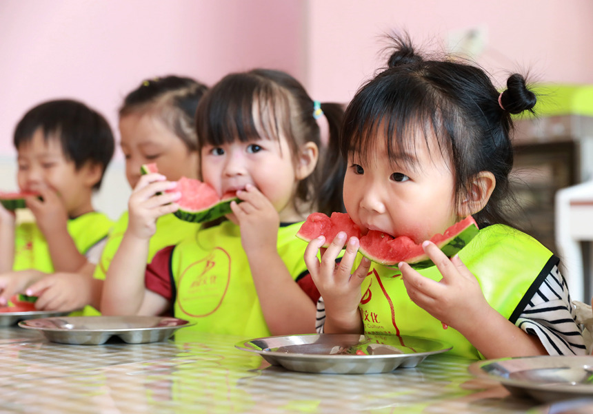 河北省邢台市任泽区智行幼儿园的小朋友在吃西瓜“啃秋”。 宋杰摄