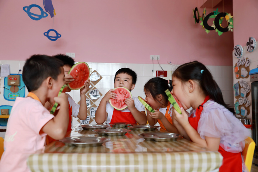 河北省邢台市任泽区智行幼儿园的小朋友在吃西瓜“啃秋”。 宋杰摄