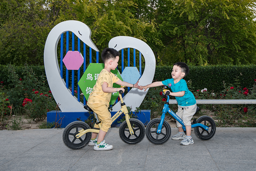 在高阳县人民公园内两个小朋友玩耍。卢建永摄