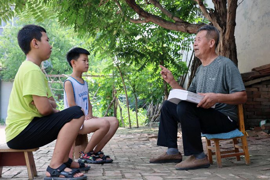 在河北省南皮县南王庄村，71岁的许汝明正在给孩子们讲述抗日战争期间牟致祥烈士为掩护部队突围壮烈牺牲的故事。鲍俊秀摄