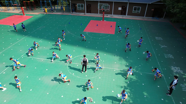 在复兴区百花小学，体育指导员指导篮球队队员进行训练。刘沛宇摄