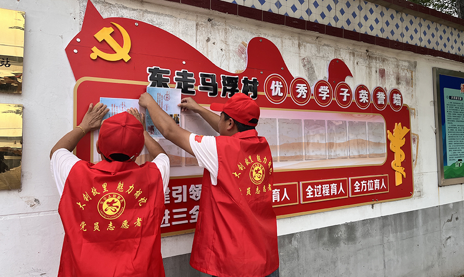 志愿者将表扬决定书放入优秀学子荣誉墙内展示。韩雨宣摄