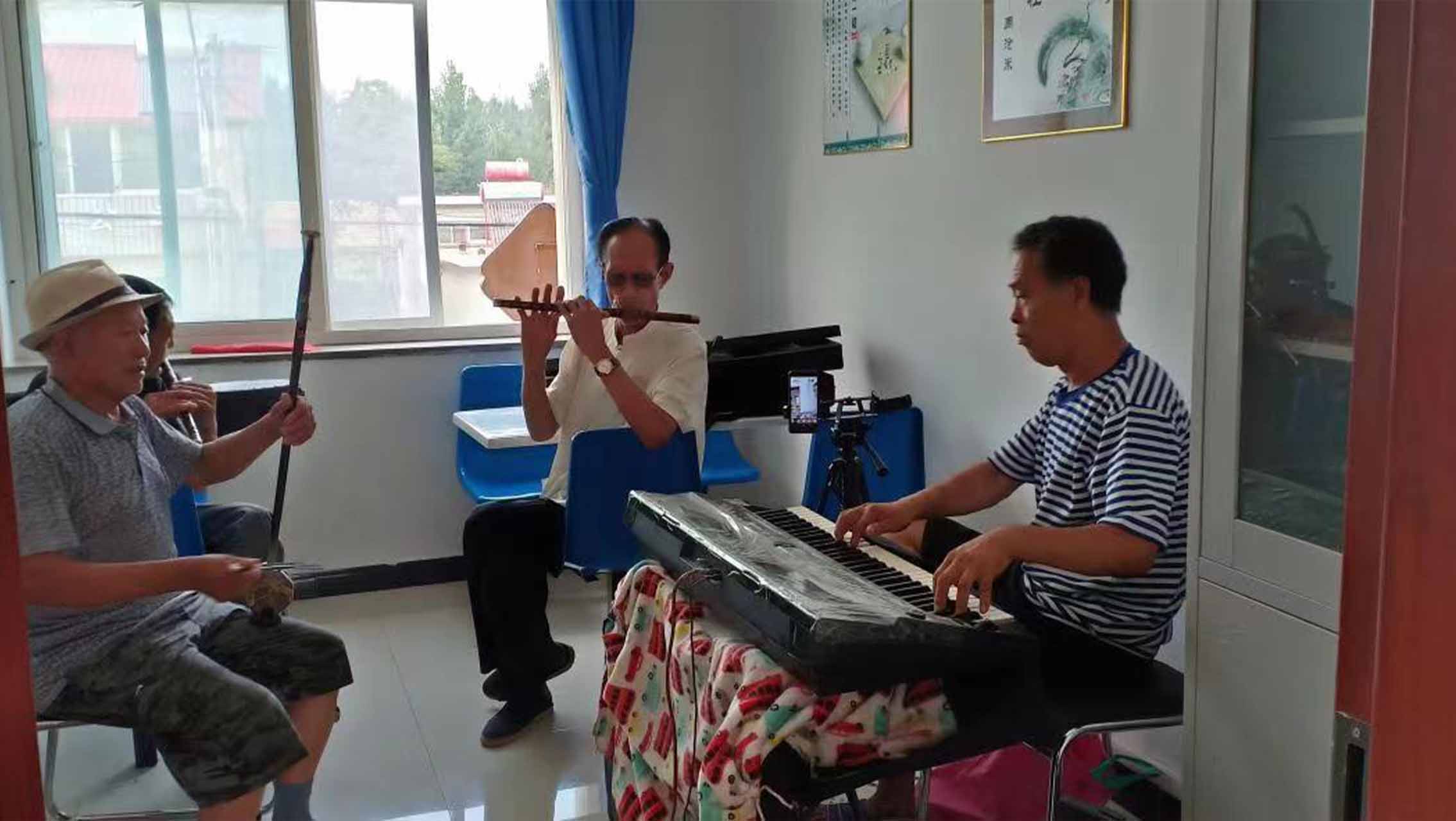 老年人在河北省卢龙县潘庄镇医养结合养老中心弹奏乐器。翟国锋摄