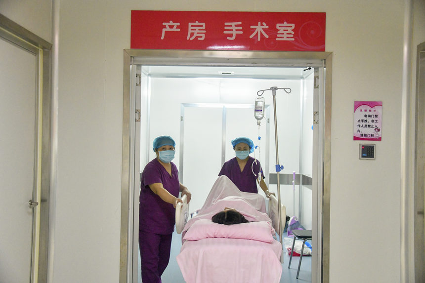 医护人员推产妇出产房。杨海斌摄