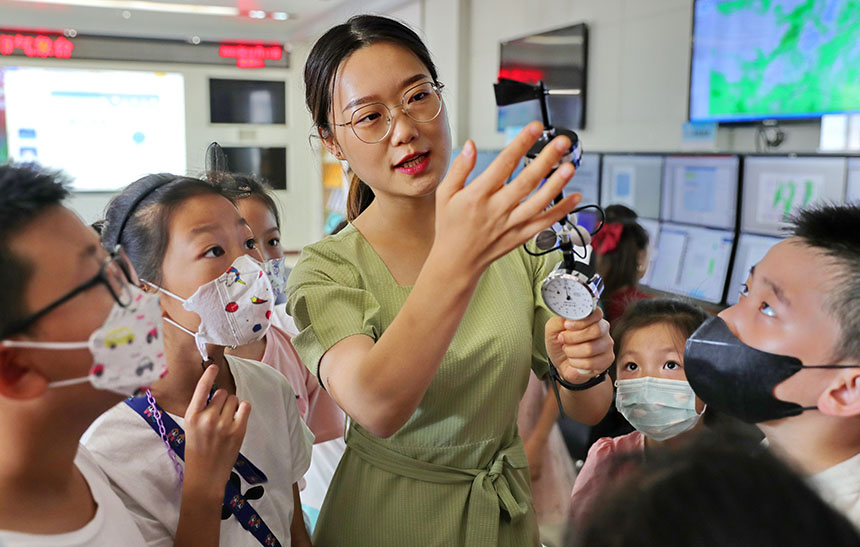 秦皇岛市气象局工作人员为海港区红桥蓝座社区小朋友讲解手持测风仪的工作原理。曹建雄摄