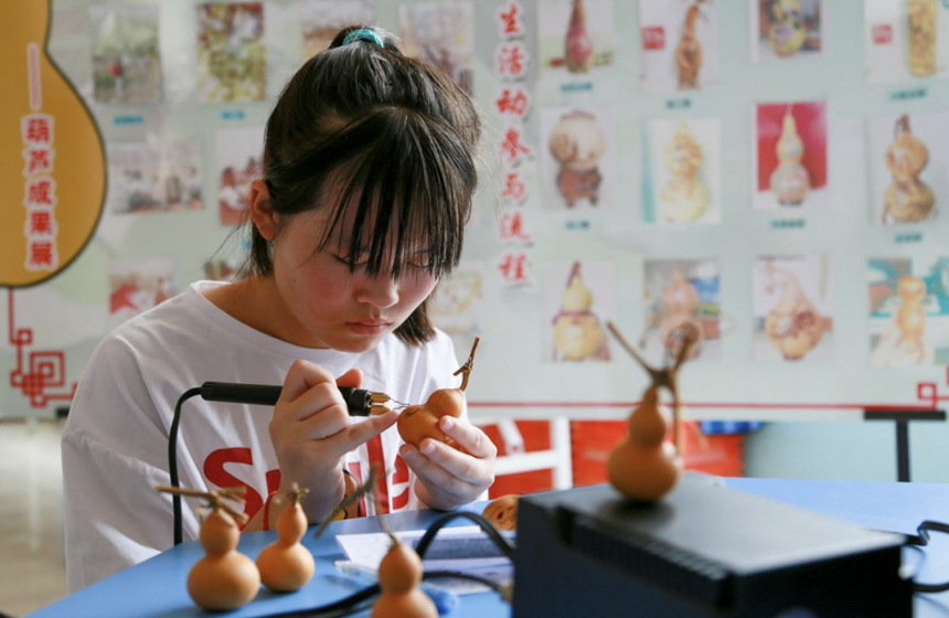 孩子正在练习葫芦烙画的基础线条创作。陈英华摄