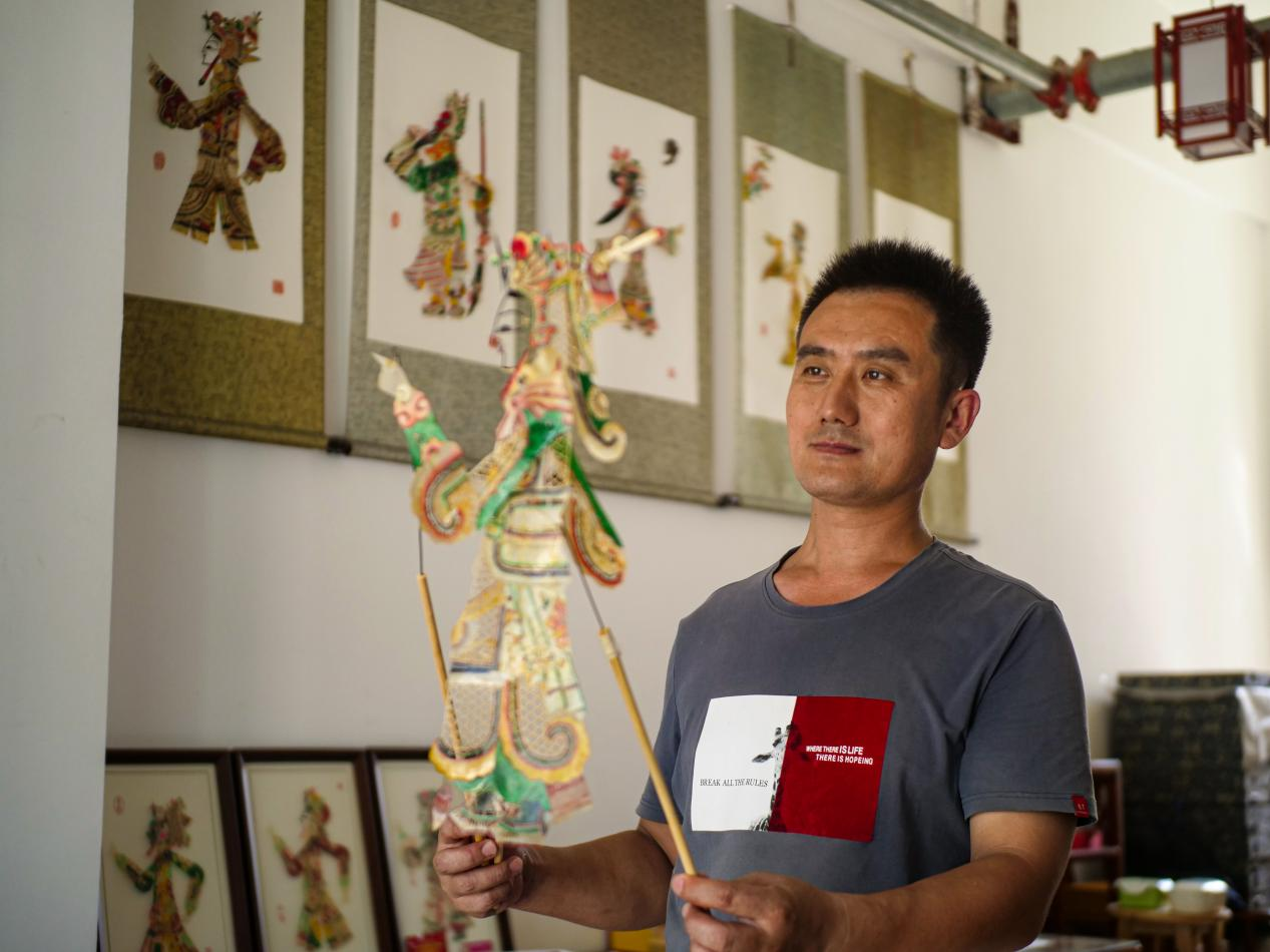 唐山市豐南區皮影雕刻藝人楊玉輝正在舞動影人。崔光攝