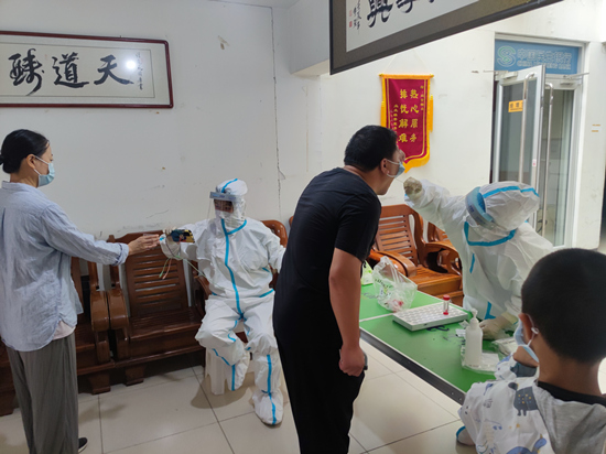 社工站工作人员志愿者在协助居委会做核酸采集。宁安街道社工站供图