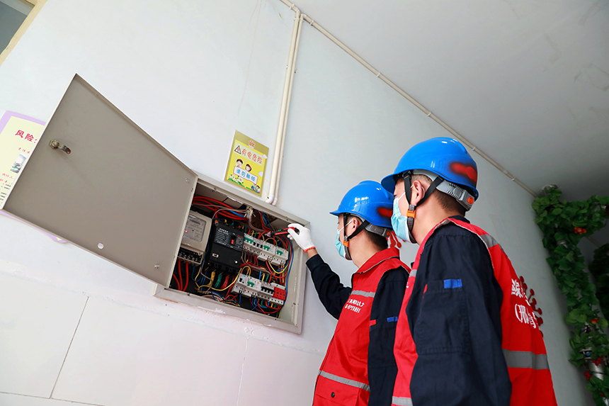 電力技術人員在河北省邢台市任澤區昌平路小學檢查線路開關。