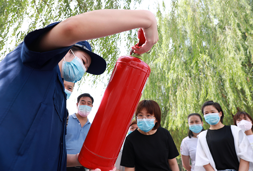 河北省邢台市任泽区消防救援大队队员在为老师们讲解灭火器使用方法。 陈惠浩摄