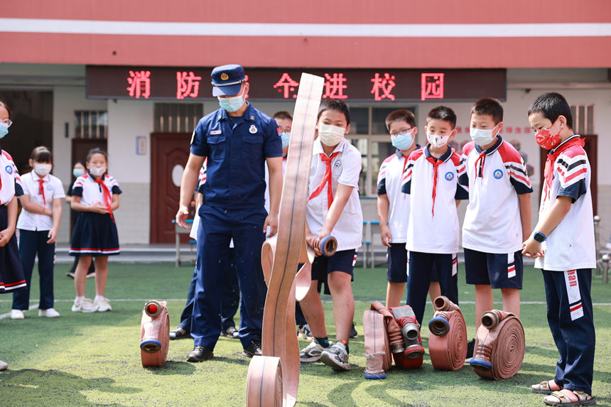 2022年9月5日，河北省邯鄲市邯山區消防救援大隊消防員教授火磨小學學生如何快速打開消防水帶。李昊攝