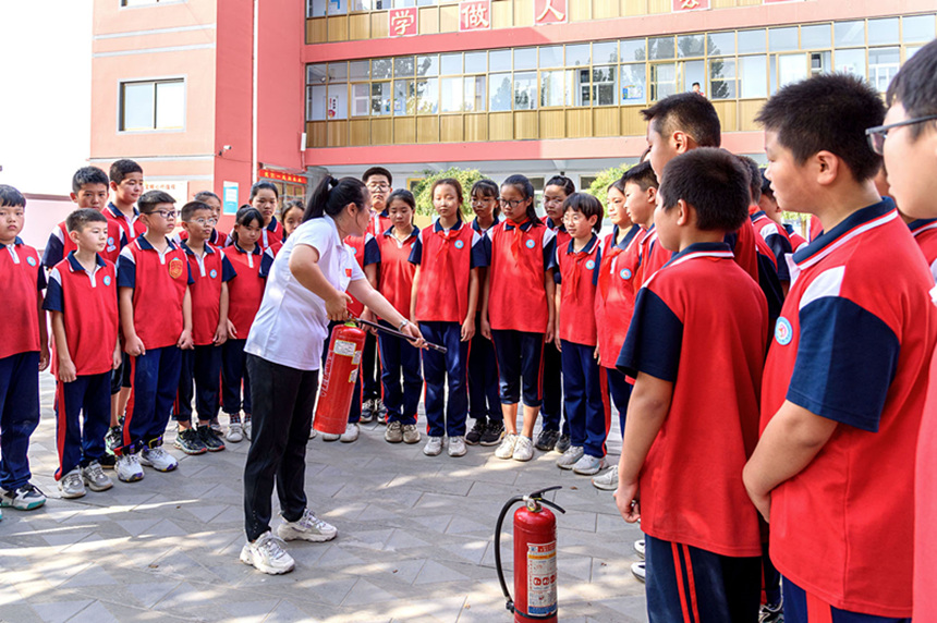 高阳县春蕾小学学生进行消防安全实操训练。 庞超英摄
