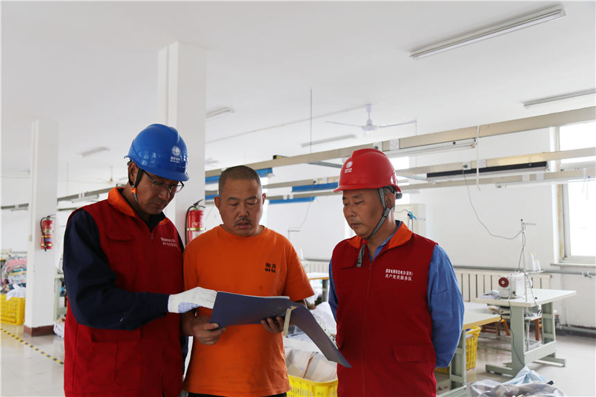 国网定兴县供电公司工作人员为定兴县瀚月纺织品制造公司讲解用电安全注意事项。 刘杰摄