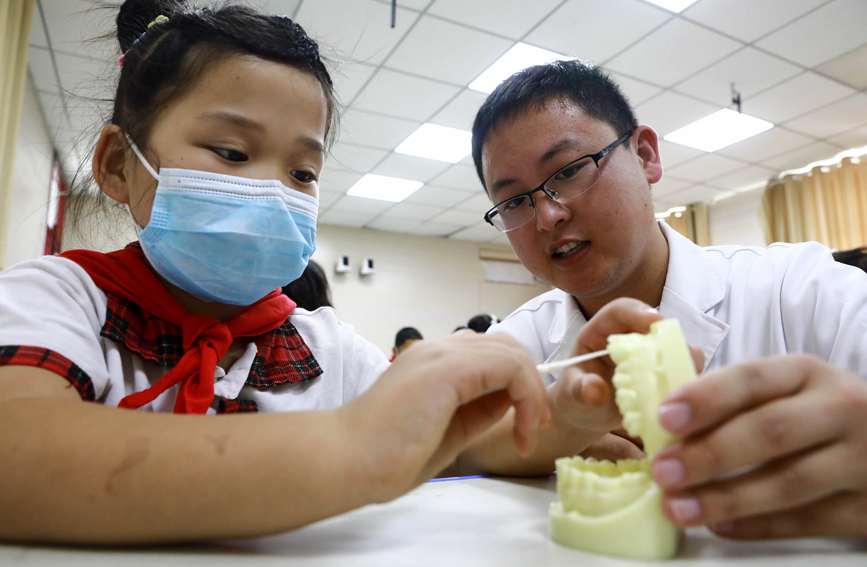 河北临城县人民医院口腔科医生在鸭鸽营小学为小朋友讲解正确的刷牙方法。王永周摄