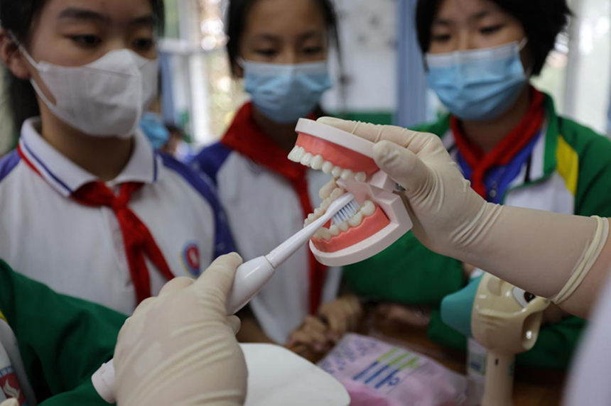 河北省邢台市广宗县妇幼保健计划生育服务中心医生在实验小学向学生讲解正确刷牙方式。 王垒摄
