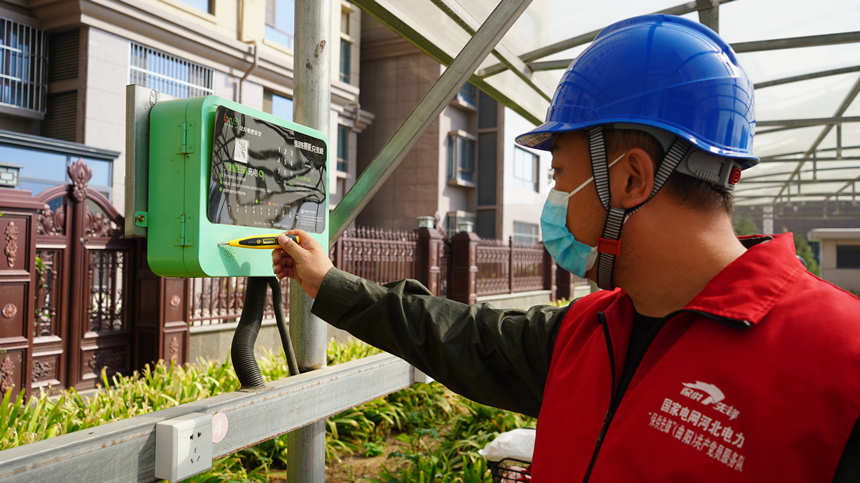 国网曲阳县供电公司党员服务队对小区内电动车充电桩进行防漏电检测。 马芊芊摄