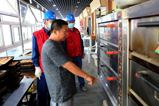 10月30日，国网赵县供电公司员工在赵州桥古镇特色商业街检查商户“全电厨房”设备。侯西果摄