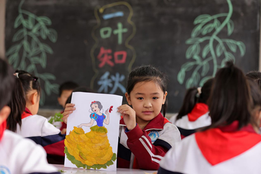 河北省邢台市广宗县东街小学的学生在展示制作的创意树叶画。 王垒摄