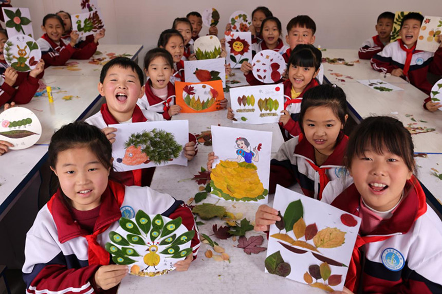 河北省邢台市广宗县东街小学的学生在展示制作的创意树叶画。 王垒摄