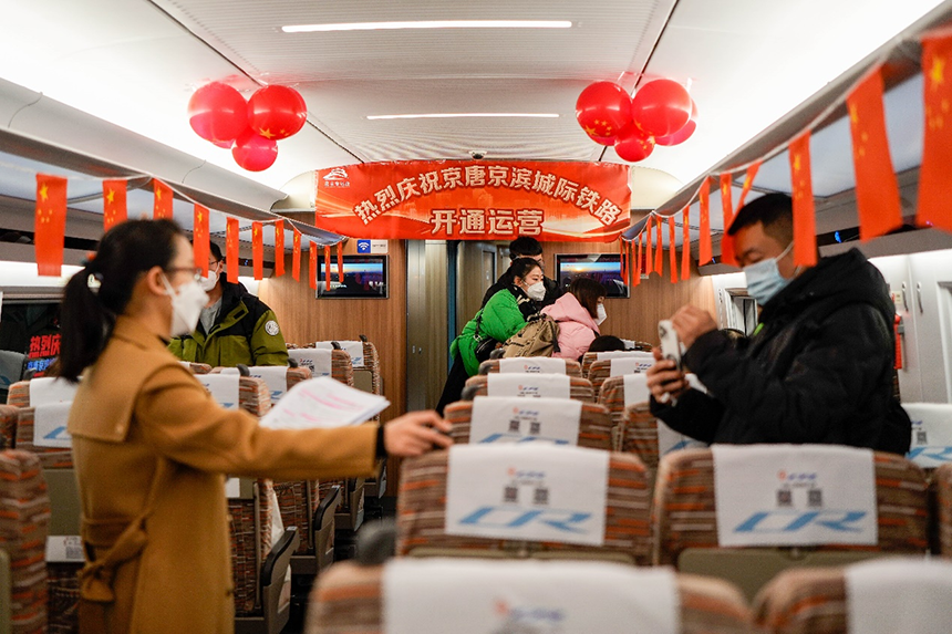 乘客们正在京唐城际铁路首趟列车上留念。赵亮摄
