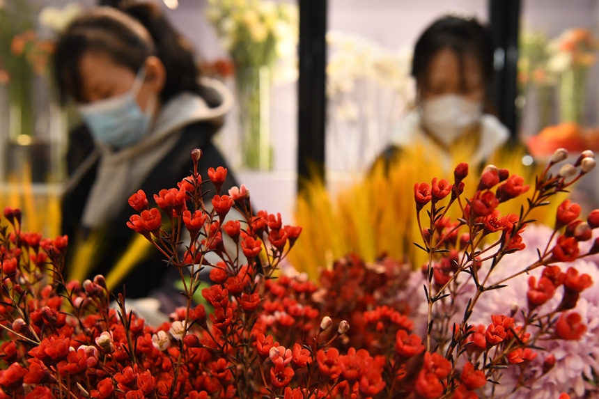 2022年12月31日，河北省邯郸市广平县一家花店内顾客在选购鲜花。程学虎摄